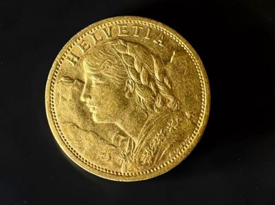 a close up of a gold coin on a black surface