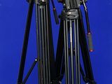 two tripod legs and a camera on a blue background