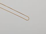 a gold chain necklace with a small diamond on it