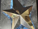 a close up of a metal star on a black surface