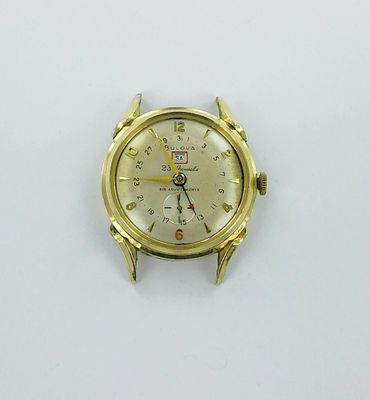 a gold watch on a white surface with a white background