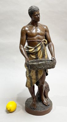 bronze statue of a man holding a basket of fruit next to a lemon