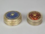 two gold and blue tins sitting next to each other