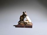 a small figurine of a mouse holding a piece of paper