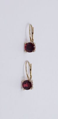 une paire de boucles d'oreilles ornées de grenats sur fond blanc