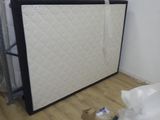 un lit avec un matelas posé dessus dans une chambre