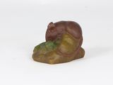 figurine of a mouse on a rock on a white background