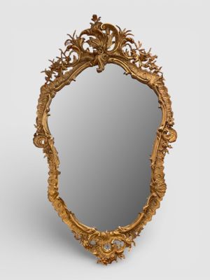 MIROIR de forme violonné en bois et stuc doré à décor de fle…