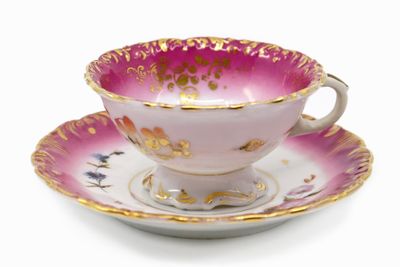 purple and gold tea cup and saucer on a white background