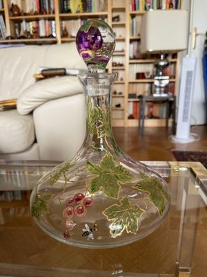 a glass vase with flowers in it sitting on a glass table