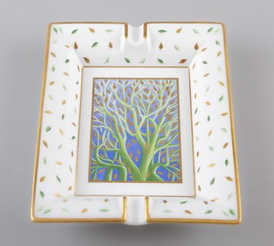 un cendrier blanc et doré orné d'une peinture représentant un arbre