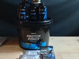 un seau rempli de protéines et un sachet de protéines