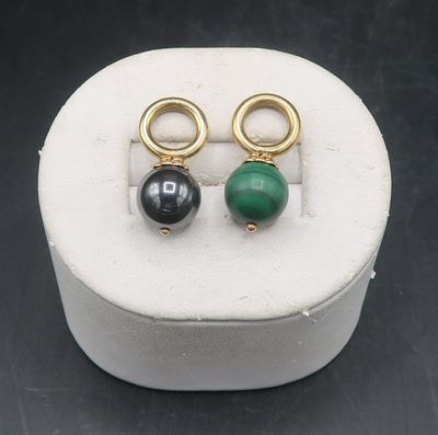 pair of green and black stone earrings in a white box