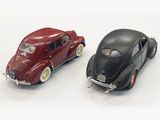 two toy cars sitting next to each other on a white surface