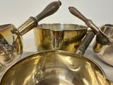 a lot of silver bowls and spoons sitting on a table