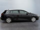 the black car is parked on the concrete floor in the room