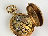 an image of a gold pocket watch on a white surface