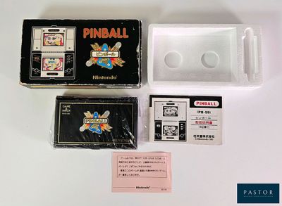 une petite boîte sur laquelle est représenté un flipper, à côté d'autres objets