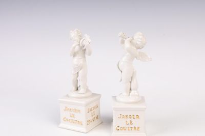 pair of white figurines of cherensils on pedestals