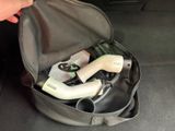 a person holding a hair dryer in a bag in the back of a car