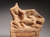 une statue antique représentant une femme et un enfant allongés sur un lit