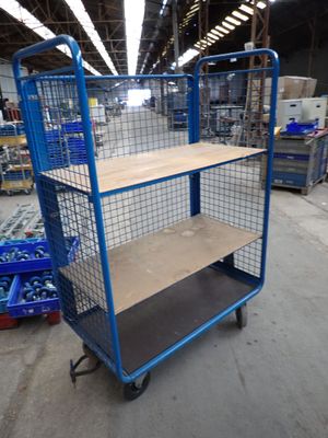 a blue cart with a shelf on it in a warehouse