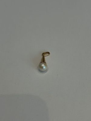 une boucle d'oreille en perle isolée sur une surface blanche