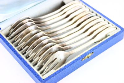 des couverts dans une boîte bleue posée sur une surface blanche