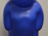 un ours en peluche bleu accroché au mur, à côté d'une prise électrique