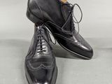 a pair of black leather shoes with laces on them
