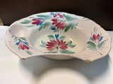 a white bowl with red and blue flowers on it