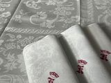 une table recouverte d'une nappe blanche ornée de motifs rouges