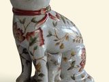 statue représentant un chat portant un collier rouge autour du cou