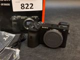 a sony camera with a box and a charger on the table