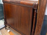 un lit avec un cadre en bois et une porte vitrée