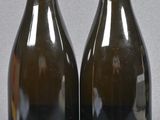 two bottles of wine sitting next to each other on a table