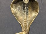 statue of a cobra on a pedestal with a black background