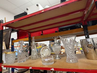 de nombreux vases et verres posés sur une étagère dans un magasin