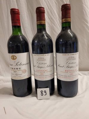 trois bouteilles de vin rouge sont alignées sur une table