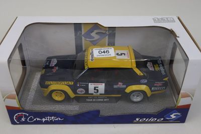 maquette d'une voiture jaune et noire dans une boîte, posée sur une surface blanche
