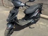 un scooter garé à côté d'un mur de briques