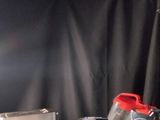 une table blanche sur fond noir, avec un sac rouge posé dessus