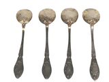 four silver spoons are lined up in a row on a white surface