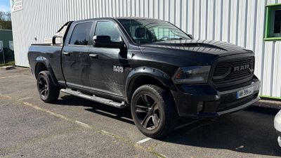 un camion noir garé devant un immeuble blanc