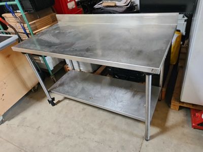une table de travail en acier inoxydable avec une étagère en dessous