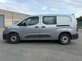 grey van parked in a parking lot in front of a building
