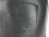 a close up of a black louis vuitton bag on a white surface