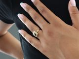 woman wearing a black shirt and a gold ring with a black diamond on it