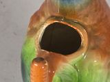 a colorful bird shaped vase with a hole in it