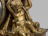 a gold clock with a statue on top of it